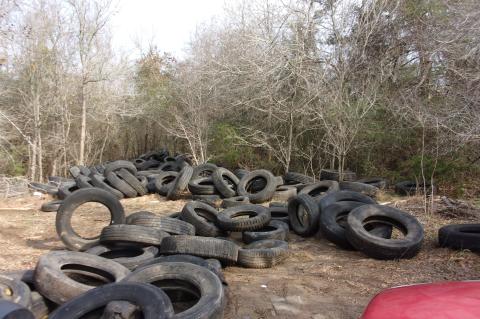 Tires litter a Cedar Creek property after being illegally dumped at the location.   Facebook / Bastrop County Sheriff’s Office
