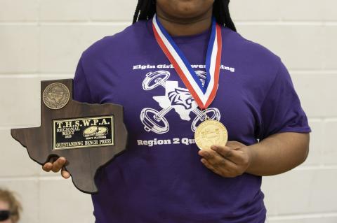 Nya Kirk Jones stands with her award earned at the regional powerlifting meet in Elgin March 4. Photo by Erin Anderson