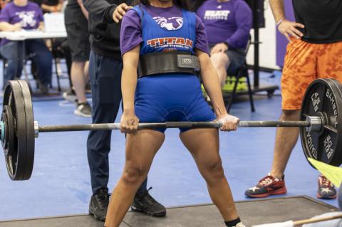 Elizabeth Nunez competes with Coach Jacob Rowe behind her during the regional powerlifting meet in Elgin March 4. Photo by Erin Anderson