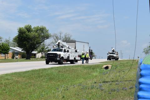Oncor personnel assess the situation of a downed power line on Texas 95 in Elgin March 31. Photo by Fernando Castro