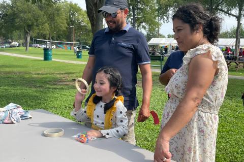 Mariza Vences plays ring toss along with her parents, Ismael and Patricia Vences, at the Sacred Heart Annual Fiesta at Elgin Memorial Park in Elgin Sept. 3. Photo by Fernando Castro