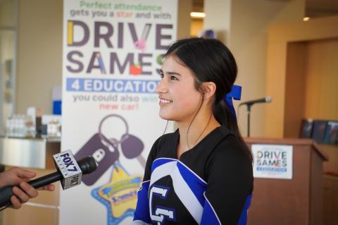 Cedar Creek High School junior Liliana Roberts talks about the “Drive Sames 4 Education” Perfect Attendance Program in Bastrop Sept. 26. Facebook / Bastrop ISD