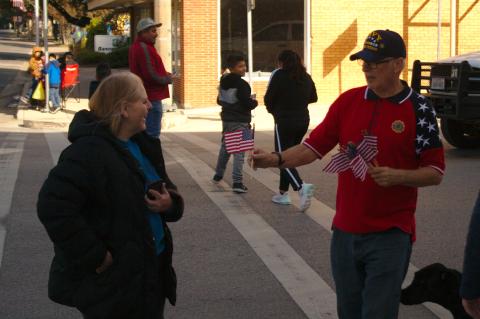 Before of the start of the parade, American Legion post commander John Quagliani (right) hands out small American flags to the parade viewers in Elgin Nov. 2, 2021. File photo