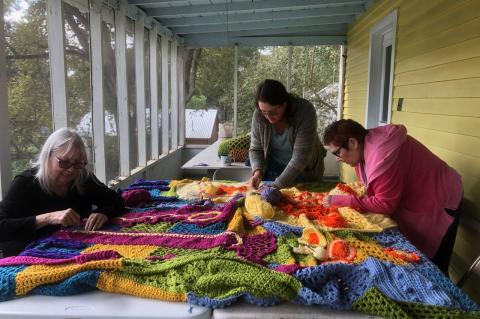 The Smithville Yarn Bombers work on the project currently on the side of the Smithville Chamber of Commerce. Courtesy photo