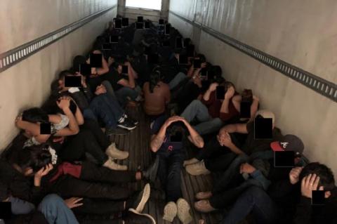 Eighty-one migrants sit in the back of a tractor trailer in this undated photo from the U.S. Department of Justice.   Courtesy photo / U.S. Department of Justice  