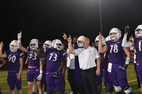 Head coach Heath Clawson and his players enjoy the sweet taste of victory after their homecoming win against Cedar Creek. Photo by Quinn Donoghue