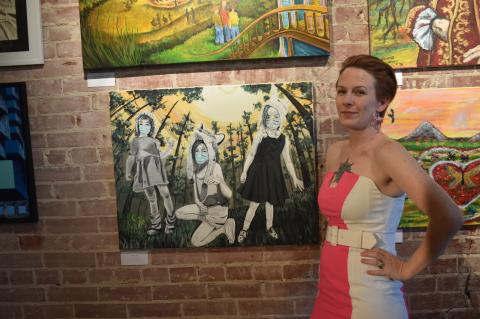  Clever Tiger owner Ashley Smith posing next to her first place painting, “Allies.” Photo by Quinn Donoghue