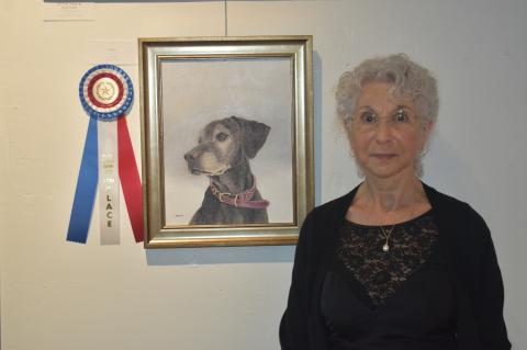 Sharon Moon showcasing her oil painting “Lexi,” which earned the third-place award. Photo by Quinn Donoghue