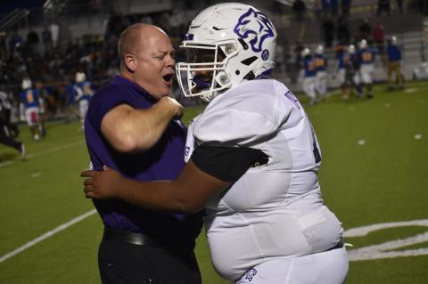 Coach Heath Clawson and offensive lineman Jackie Williams are jubilant after a playoff clinching win against Pflugerville.  Photo by Quinn Donoghue