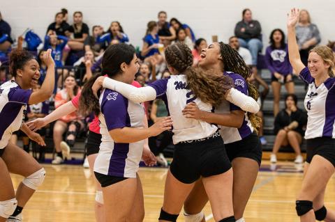 The Elgin High School varsity volleyball team celebrates together on Sept. 20, 2022, after the Lady Wildcats won a set at home vs. Cedar Creek High School. Photo by Erin Anderson