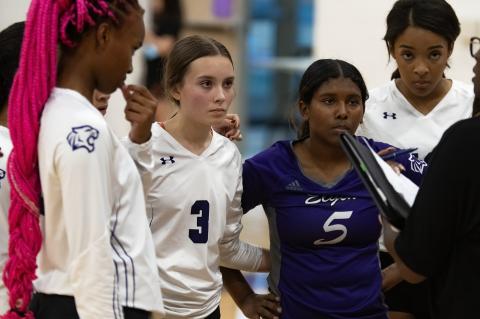 Elgin High School varsity volleyball freshman Meta Elliott (3) and sophomore Trinity Martinez (5) listen to head coach Patricia Rivers-Taylor (right) on Aug. 25 during a Lady Wildcats’ home match vs. Meridian World School. Photo by Marcial Guajardo