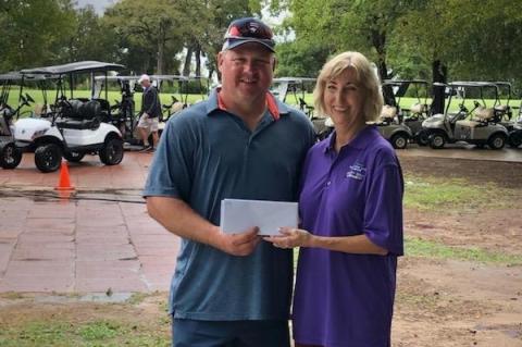 Robert Justice of TriCounty Feed accepts the second place reward from Ruth Hyatt following the Relay For Life of Elgin Golf Tournament. Photo courtesy of Ruth Hyatt