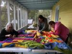 The Smithville Yarn Bombers work on the project currently on the side of the Smithville Chamber of Commerce. Courtesy photo